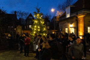 Students and Staff singing carols by the Christmas treet