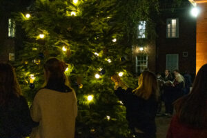 Students and Staff singing carols by the Christmas tree