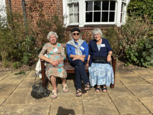 alumni seated on a bench on the terrace