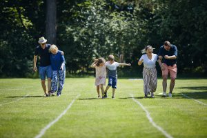 Three generations taking part in a three-legged race at the Garden Party