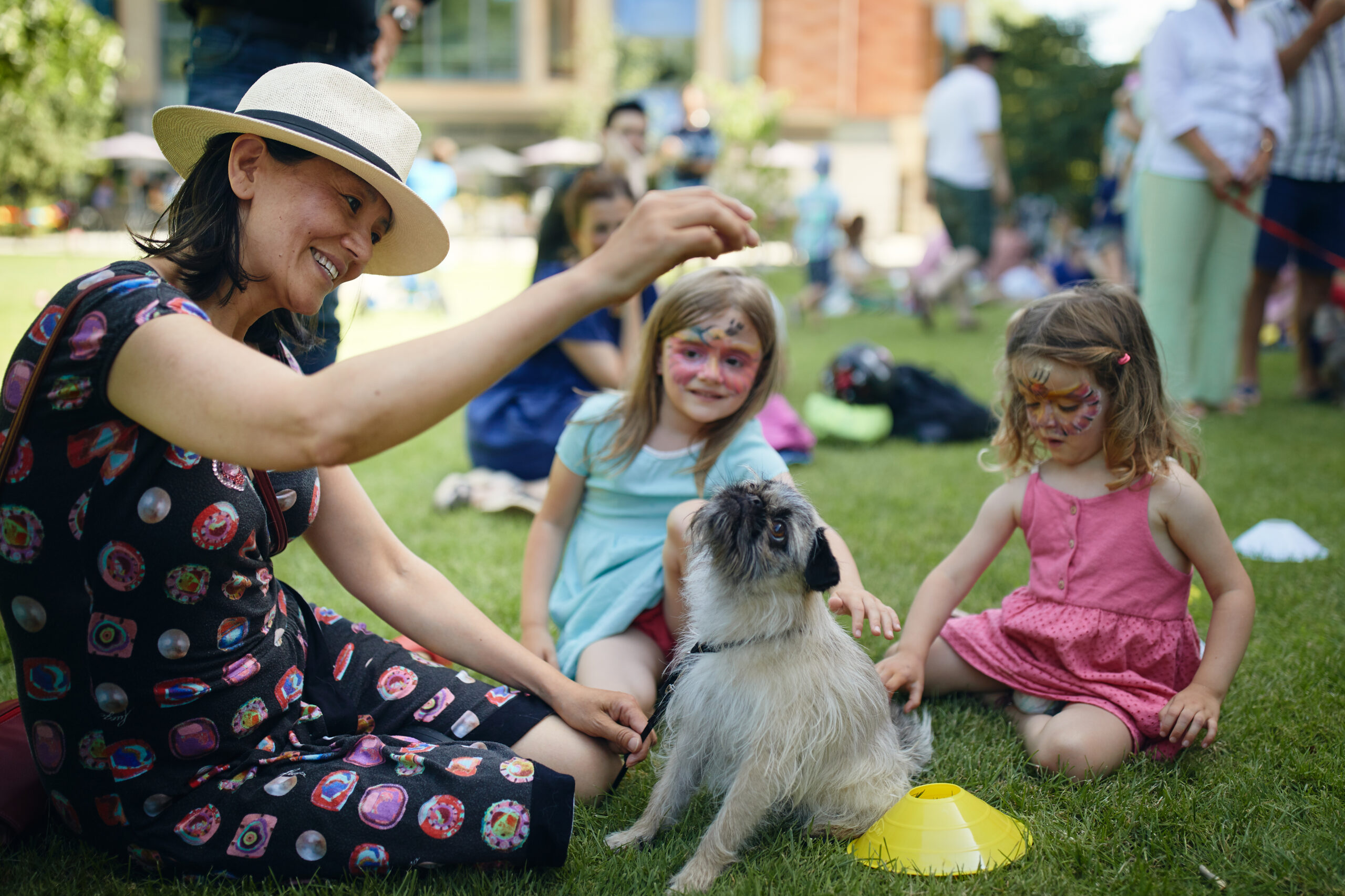 Guests playing with dog at summer party