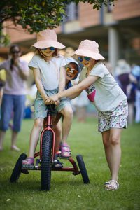 Three children playing on a tricycle