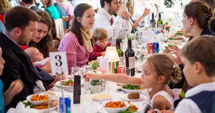 wedding guests eating at table with small children and a baby